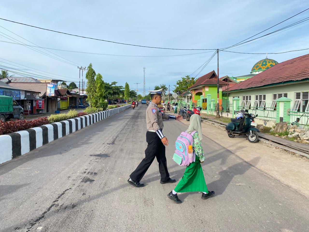 Personil Sat Lantas Lamandau Bantu Menyebrangkan Anak Sekolah